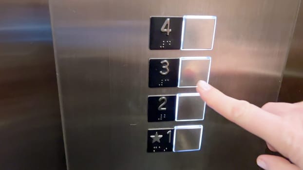 An elevator control panel displaying a set of floor buttons, with the second and third floors highlighted, indicating the current selections made by the users.