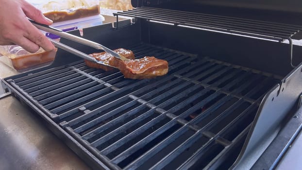 Several thick steaks with grill marks cooking to perfection on an outdoor grill, capturing the essence of a sunny barbecue day.