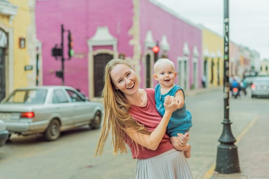 Mother and baby son tourists explore the vibrant streets of Valladolid, Mexico, immersing herself in the rich culture and colorful architecture of this charming colonial town.