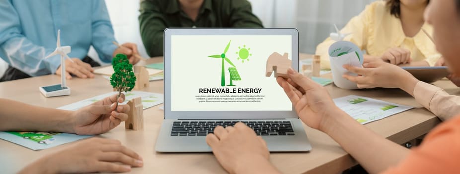 Renewable energy logo displayed on green business laptop while business team represented green design to customer. ESG environment social governance and Eco conservative concept. Closeup. Delineation.