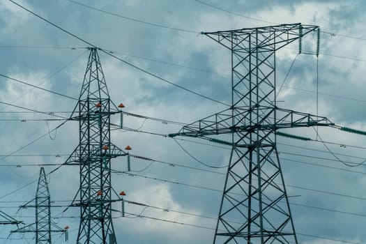 High voltage towers with sky background. Power line support with wires for electricity transmission. High voltage grid tower with wire cable at distribution station. Energy industry, energy saving.