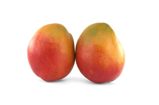 Two mangoes with a blend of red and yellow tones on their skin isolated against a white background