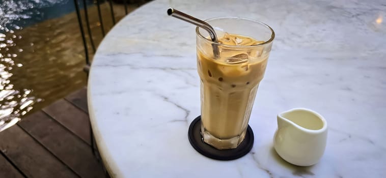 Fresh iced coffee in glass with frothy cream for your design, Food concept in style, copy space for content creation