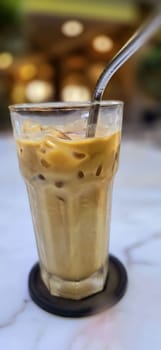 Fresh iced coffee in glass with frothy cream for your design, Food concept in style, copy space for content creation