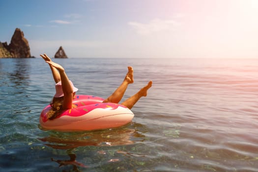 Summer vacation woman in hat floats on an inflatable donut mattress. Happy woman relaxing and enjoying family summer travel holidays travel on the sea