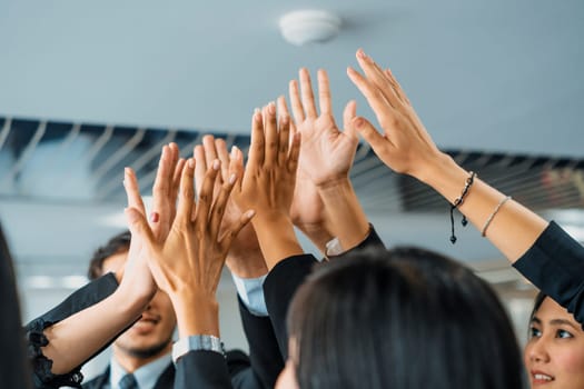 Many happy business people raise hands together with joy and success. Company employee celebrate after finishing successful work project. Corporate partnership and achievement concept. uds