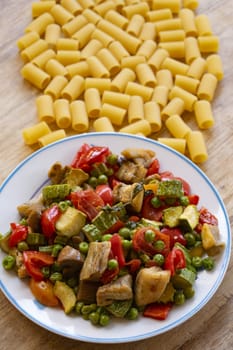 pasta with varied vegetables on a wooden table