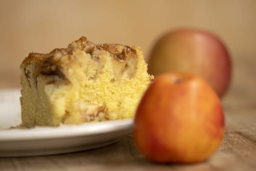 slice of homemade apple pie with near two fruits