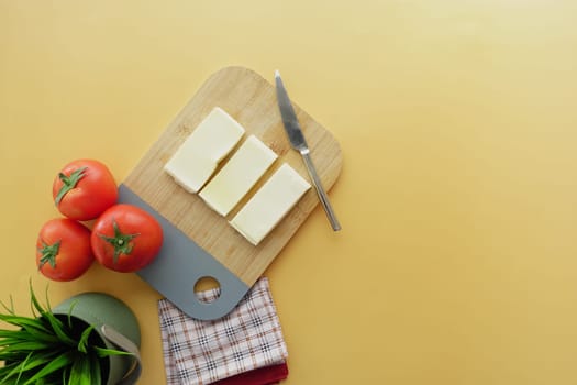 Slicing cheese into pieces on a chopping board ,