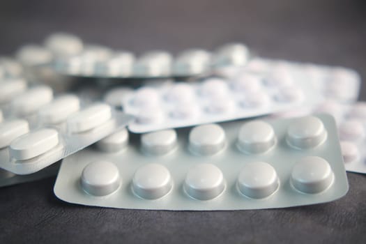 Close up of pills of blister pack on table .