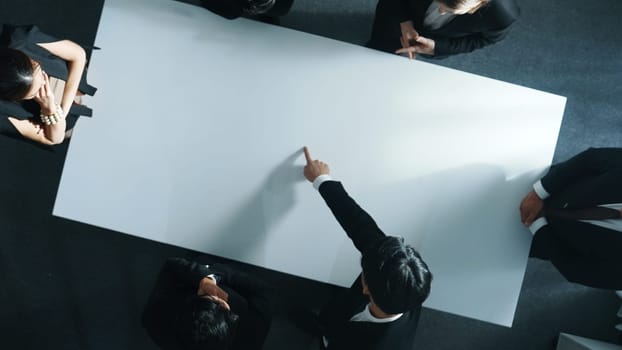 Top down aerial view of smart cooperate businessman discussing about marketing strategy. Diverse business group brainstorming idea startup project and financial plan at meeting room. Directorate.