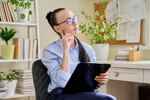Portrait of serious female psychotherapist with clipboard at workplace. Professional mental therapist, counselor, psychologist, social worker. Health care service psychology psychotherapy treatment