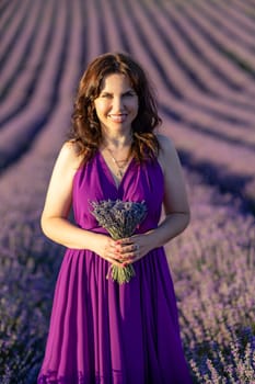 A woman in a purple dress is holding a bouquet of lavender flowers. She is smiling and standing in a field of lavender