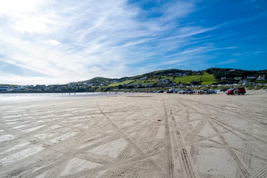DOWNINGS, IRELAND - JULY 31 2022: Holiday makers enjoying the beach.