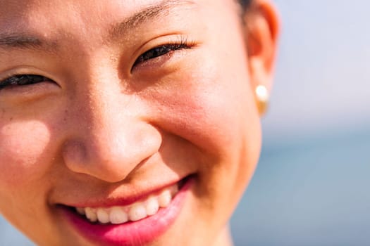 close up portrait of a cute asian woman with invisible braces smiling happy looking at camera, dental health and beauty concept