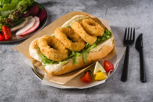 Deep fried squid in bread with greens on the side. Squid sandwich