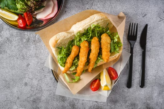 Deep fried shrimp in bread with greens on the side. Shrimp sandwich