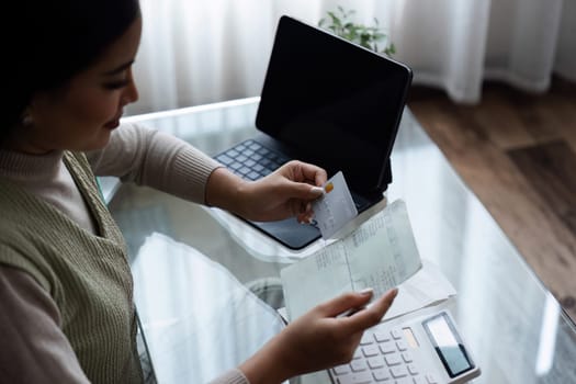 Woman holding credit card and savings account book, saving money, household expenses, monthly bills.