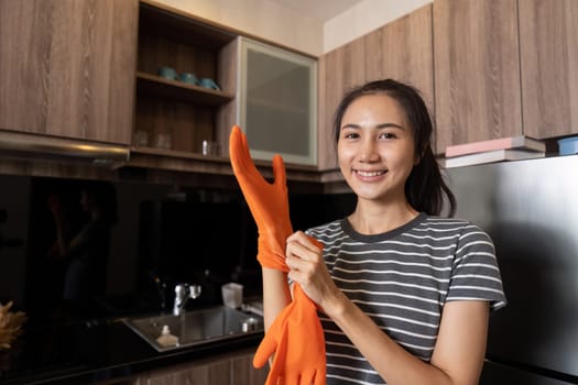 Female housekeeper smile and wearing glove, preparing to cleaning home.