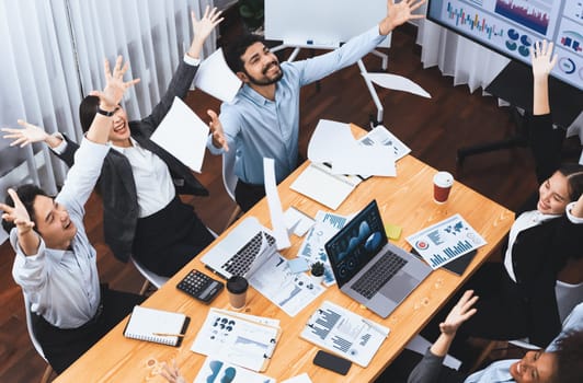 Top view office worker celebrate in meeting room, throwing paperwork in the air. Excitement and freedom expression from business people throw analysis financial paper in celebratory gesture. Concord