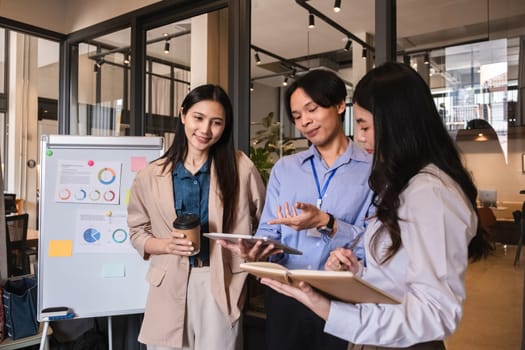 A team of business people stands together to talk, exchange ideas and summarize the results of the meeting after the meeting in the office..