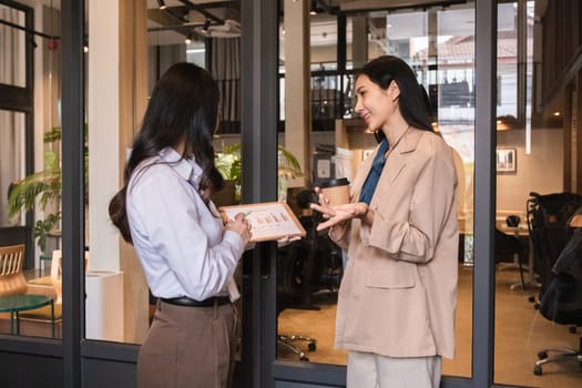 A team of businesswomen stood and talked and exchanged ideas. Brainstorm together in the office.