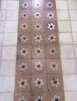 Vintage-style rustic patterned floor tiles in detailed close-up.
