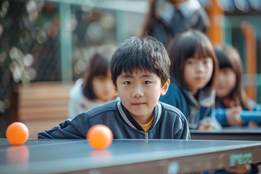 Asian children play table tennis or ping pong outdoors.