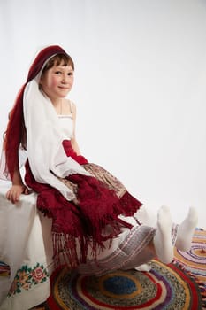 Portrait of Little girl in a stylized Tatar national costume on a white background in the studio. Photo shoot of funny young teenager who is not a professional model