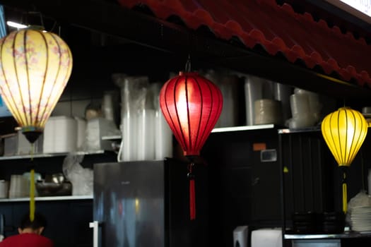 The restaurant is adorned with a row of colorful lanterns hanging from the ceiling, creating a vibrant atmosphere in the room