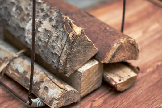 A stack of Brown logs rests on a Hardwood plank flooring. The Wood stain enhances the natural beauty of the Floor