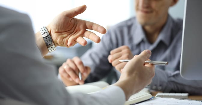 Close-up of gesturing male hands. Businessman explaining project details to partner in office. Conference of people brainstorming on development of company. Boss and employee wearing watch