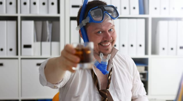 Man wearing suit and tie in goggles and snorkel hold in arm glass of cola at workplace in office closeup. Count days to leave annual day off workaholic resort idea ticket sale concept