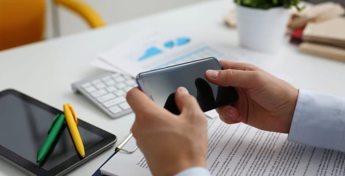 Businessman holds a new smartphone in his hand The mobile application market shows a display you can insert your image for advertising or financial statistics.