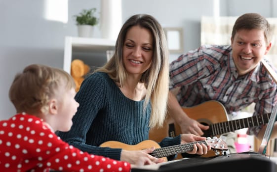 Happy family plays musical instruments on background of new apartment. Credit for good education concept. Portrait people leading healthy lifestyle.