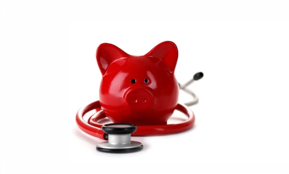 Red piggy bank with stethoscope isolated on white background. Medical insurance concept