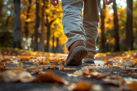 A person is walking through a forest with leaves on the ground. The person is wearing a pair of white shoes