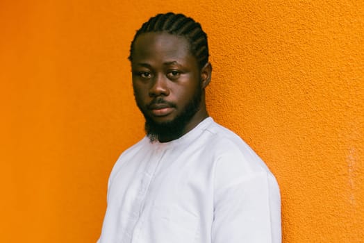 Close up portrait of a happy african american man smiling wearing ethnic dashiki clothes outdoor in summer street wall. Millennial generation student and youth. Copy space.