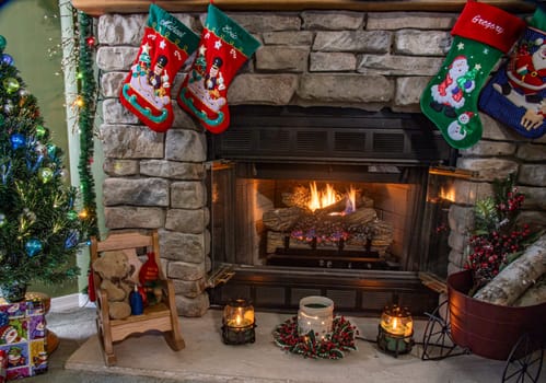 A fireplace with a red and green stocking hanging from it. The stocking is decorated with a santa and a snowman