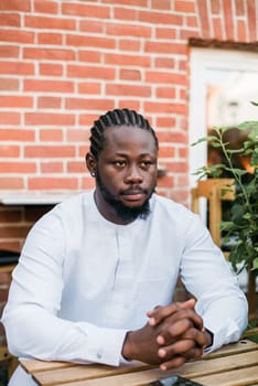 Cheerful male tourist portrait dress in white wear dashiki ethnic smiling at city street or small town background. African American travel model have free time. Millennial generation and gen z people.