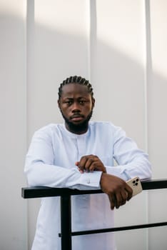 Cheerful male tourist portrait dress in white wear dashiki ethnic smiling at city street or small town background. African American travel model have free time. Millennial generation and gen z people.