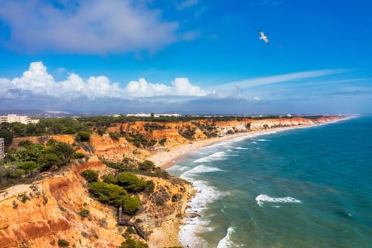 Aerial seascape and coastline cliffs of Praia do Barranco das Belharucas beach, in Algarve region in South Portugal. Praia do Barranco das Belharucas beach, Albufeira, Algarve, Portugal.