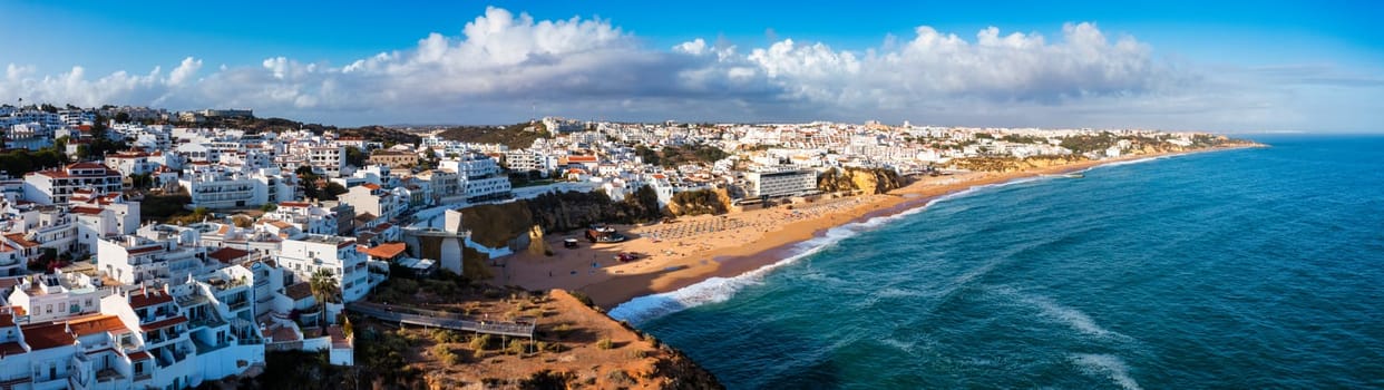 Aerial view of seaside Albufeira with wide beach and white architecture, Algarve, Portugal. Wide sandy beach in city of Albufeira, Algarve, Portugal. Aerial view of Albufeira town, Algarve, Portugal.