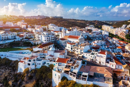 Aerial view of seaside Albufeira with wide beach and white architecture, Algarve, Portugal. Wide sandy beach in city of Albufeira, Algarve, Portugal. Aerial view of Albufeira town, Algarve, Portugal.