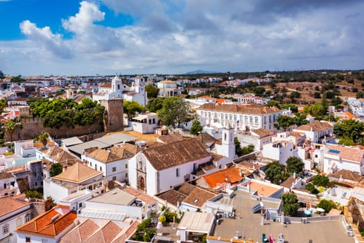 View on historic town of Tavira with Roman bridge over River Gilao, Algarve, Portugal. Cityscape of the Tavira old town with Clock tower, St Marys church, Algarve region, Portugal. 