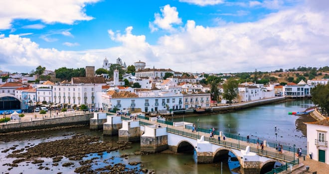 View on historic town of Tavira with Roman bridge over River Gilao, Algarve, Portugal. Cityscape of the Tavira old town with Clock tower, St Marys church, Algarve region, Portugal. 