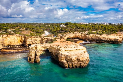 Natural arch above ocean, Arco de Albandeira, Algarve, Portugal. Stone arch at Praia de Albandeira, Lagoa, Algarve, Portugal. View of the natural arch Arco da Albandeira in the Algarve, Portugal.