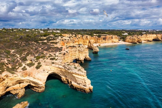 Praia da Marinha, beautiful beach Marinha in Algarve, Portugal. Navy Beach (Praia da Marinha) with flying seagulls over the beach, located on the Atlantic coast in Lagoa Municipality, Algarve.