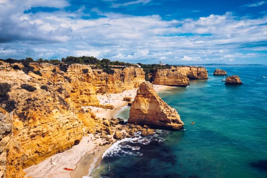 Praia da Marinha, beautiful beach Marinha in Algarve, Portugal. Navy Beach (Praia da Marinha) with flying seagulls over the beach, located on the Atlantic coast in Lagoa Municipality, Algarve.