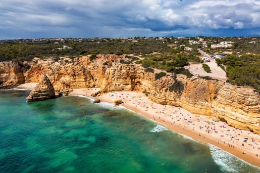 Praia da Marinha, beautiful beach Marinha in Algarve, Portugal. Navy Beach (Praia da Marinha) with flying seagulls over the beach, located on the Atlantic coast in Lagoa Municipality, Algarve.